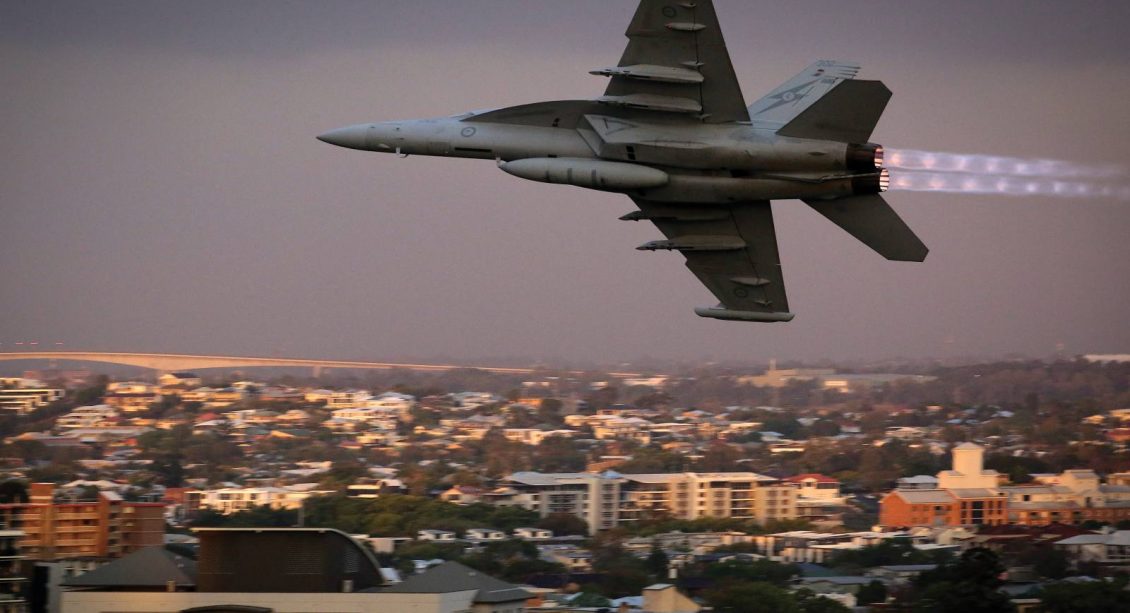 EA-18G Growler airborne electronic attack aircraft flying at twilight over city