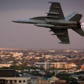 EA-18G Growler airborne electronic attack aircraft flying at twilight over city