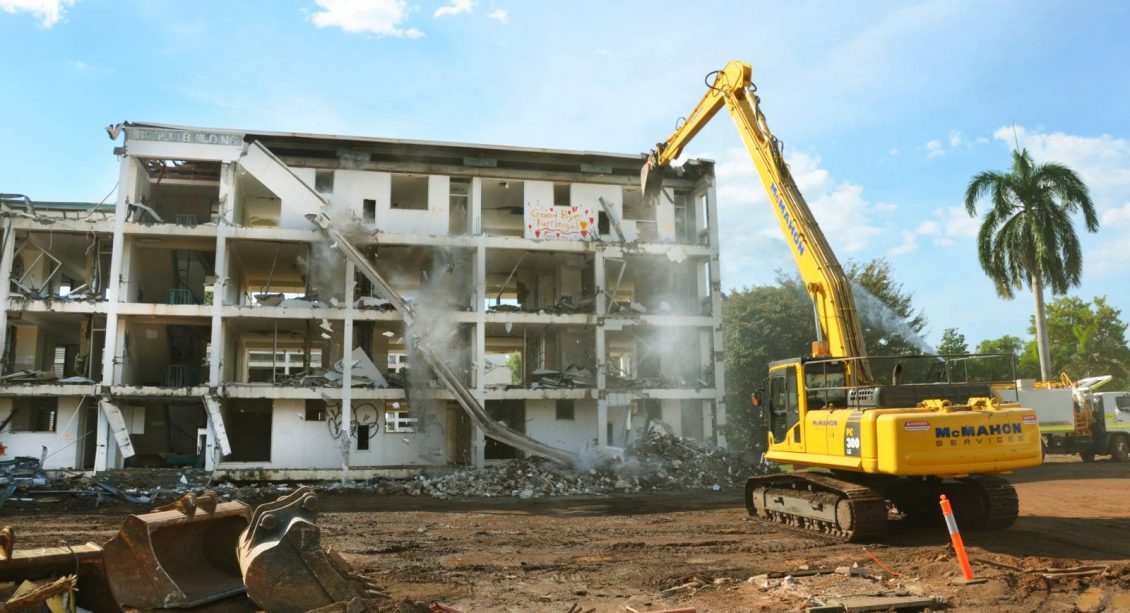 Excavator performing demolition on four-level medium density building at Kurringal Flats
