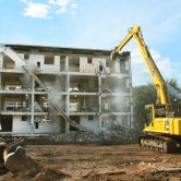 Excavator performing demolition on four-level medium density building at Kurringal Flats